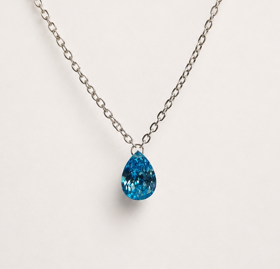 Blue pear shaped Floating Diamond necklace on an ivory background