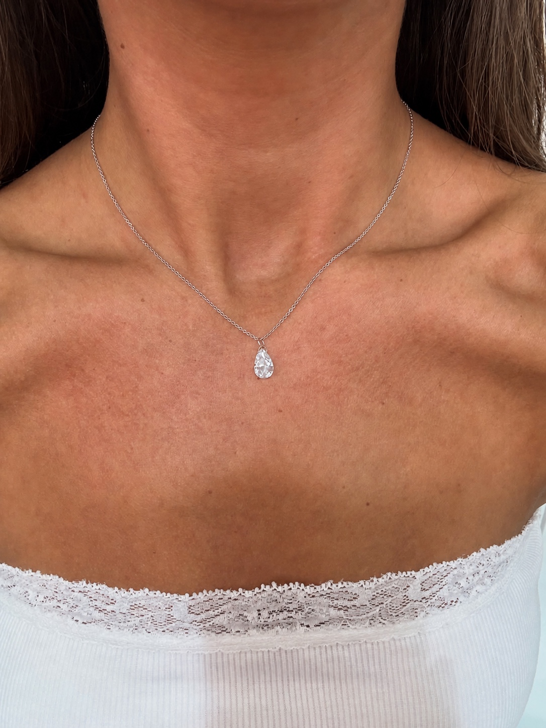 White pear shaped Floating Diamond necklace worn on a delicate chain